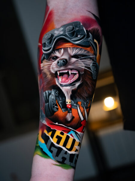 Comic Pop Art Tattoo, Tattoo zeigt einen Controller und einen bekleideten Waschbär.