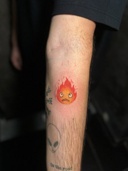 Comic Pop Art Tattoo, Tattoo zeigt einen kleinen Feuerball mit Gesicht.