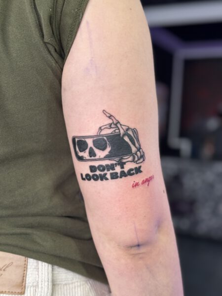 Tattoo Stil Black and Grey - Oberarm Tattoo Totenkopf in Handy mit Schriftzug "Don't Look Back".