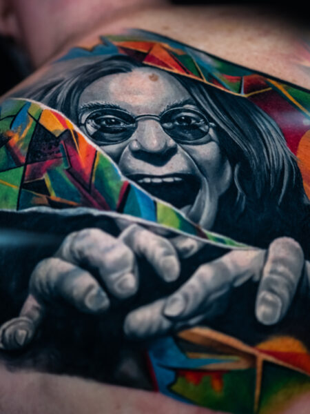 Comic Pop Art Tätowierung, Tattoo zeigt einen Ozzy Osbourne mit einem verrückten Gesichtsausdruck.