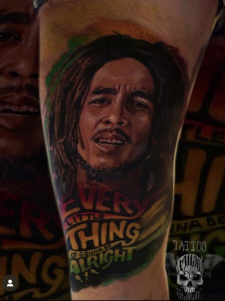 Color Realistic Tattoo Stil, Tattoo zeigt Bob Marley mit dem Schriftzug "every little thing's gonna be alright".